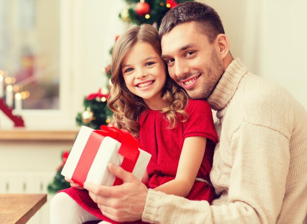 familie, weihnachten, x-mas, glück und personenkonzept - lächelnder vater und tochter, die geschenkbox halten