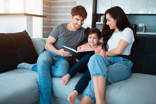 Familie zu Hause liest ein Buch.