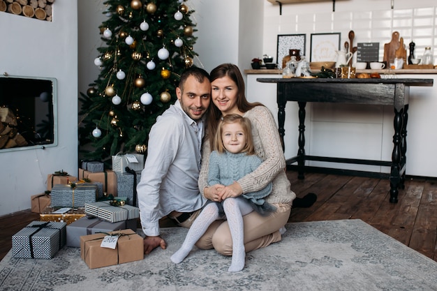 Familie zu Hause nahe Weihnachtsbaum und Weihnachtsgeschenken