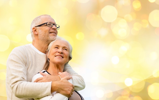 Familien-, Beziehungs-, Alters- und Personenkonzept - glückliches älteres Paar über Feiertagslichthintergrund