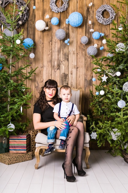 Familien-, Feiertags- und Weihnachtskonzept - Mutter und Sohn nahe dem Weihnachtsbaum