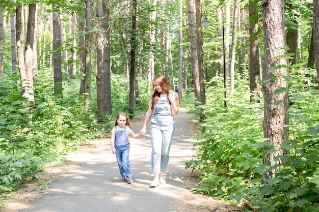Familien-, Natur- und Menschenkonzept - Mutter und Tochter verbringen Zeit miteinander auf einem Spaziergang im grünen Park