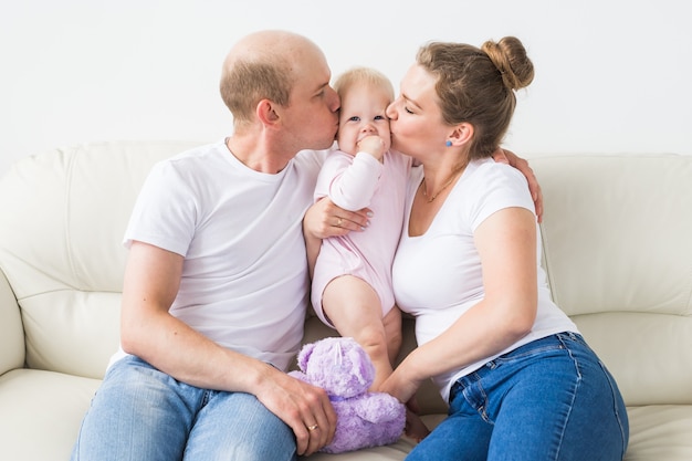 Familien- und Kinderkonzept - Lächelnde Mutter und Vater halten ihre neugeborene kleine Tochter zu Hause