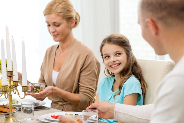 familien-, urlaubs-, generations- und personenkonzept - lächelnde familie, die zu hause zu abend isst