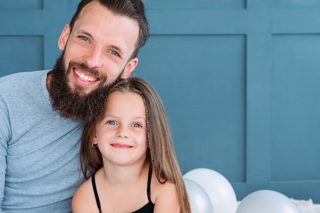 Familienbande und liebevolle Beziehung. Mann und seine Tochter umarmen sich und lächeln glücklich zusammen.