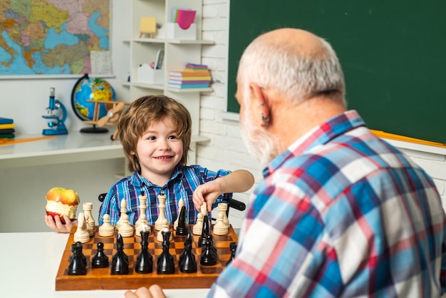 Familienbeziehung zwischen Großvater und Enkel Großvater, der den Schuljungen unterrichtet, der Schachportr spielt