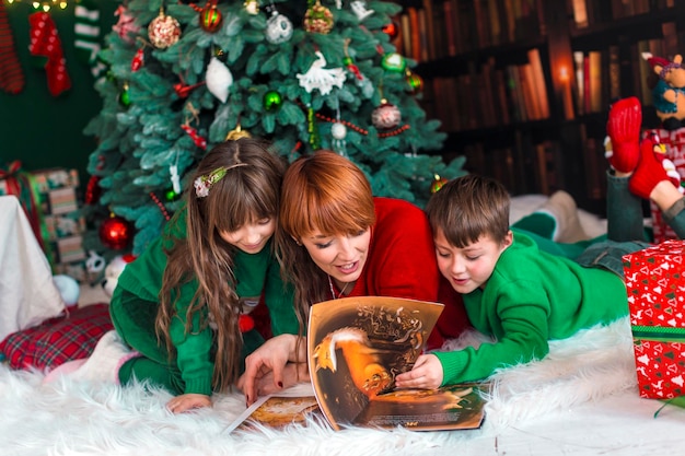 Familienbuchlesung in der Nähe des Weihnachtsbaums