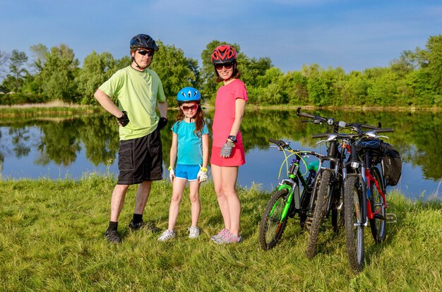 Familienfahrrad fahren im Freien, aktive Eltern und Kind Radfahren und Entspannen in der Nähe von schönen Fluss