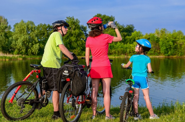 Familienfahrrad fahren im Freien, aktive Eltern und Kind Radfahren und Entspannen in der Nähe von schönen Fluss