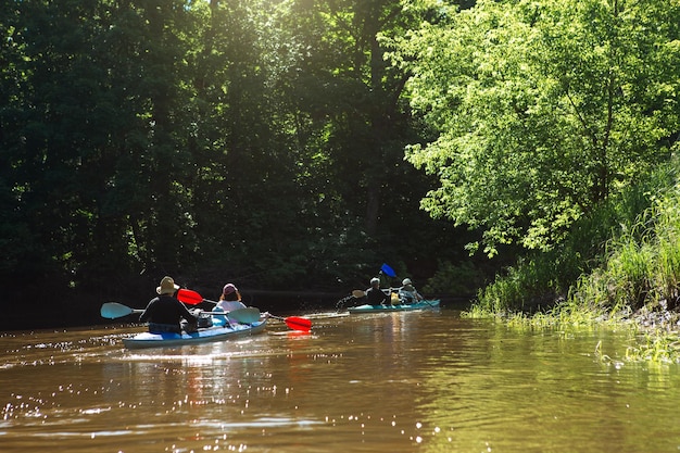 Familienkajakausflug Mann und Frau und älteres Ehepaar Senior und Seniora Ruderboot auf dem Fluss eine Wasserwanderung ein Sommerabenteuer Umweltfreundlicher und extremer Tourismus aktiver und gesunder Lebensstil