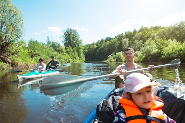 Familienkajakausflug Vater und Tochter und älteres Ehepaar Senior und Seniorein Ruderboot auf dem Fluss eine Wasserwanderung ein Sommerabenteuer Umweltfreundlicher und extremer Tourismus aktiver und gesunder Lebensstil