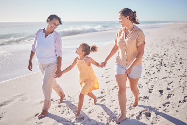 Familienlächeln am Strand Mutter und Großmutter halten Händchen mit Mädchen im Urlaub Kinder lieben Urlaub am Meer glückliche Oma im Ruhestand und gemeinsam im Sand spazieren, während sie sich als Gruppe entspannen