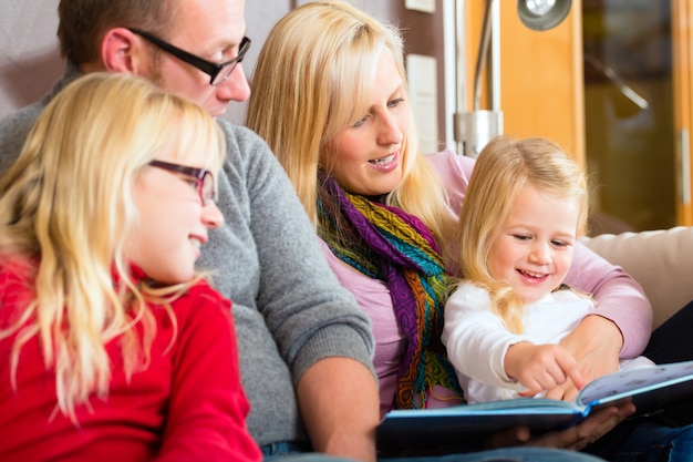 Familienlesegeschichte im Buch auf Sofa im Haus