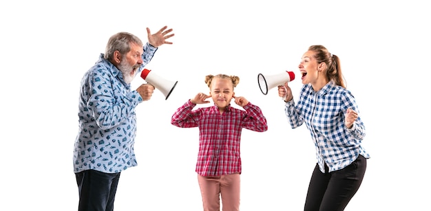 Familienmitglieder streiten miteinander auf weißem Studiohintergrund. Konzept der menschlichen Emotionen, Ausdruck, Generationenkonflikt. Frau, Mann und kleines Mädchen. Elternskandale, Kinderprobleme.