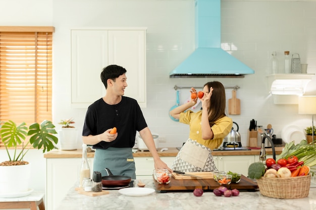 Foto familienpaar tanzen lachend zusammen essen zu hause zubereiten