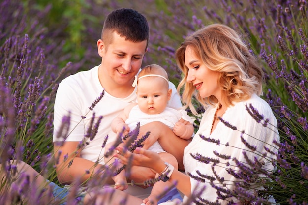 Familienporträt Mutter Vater und Baby auf dem Lavendelfeld haben gemeinsam Spaß. Glückliches Paar mit Kind