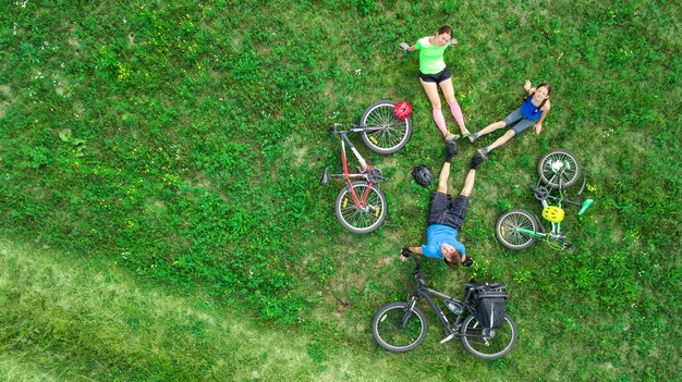 Familienradfahren auf Fahrrädern im Freien Luftaufnahme von oben, glückliche aktive Eltern mit Kind haben Spaß und entspannen auf Gras, Familiensport und Fitness am Wochenende