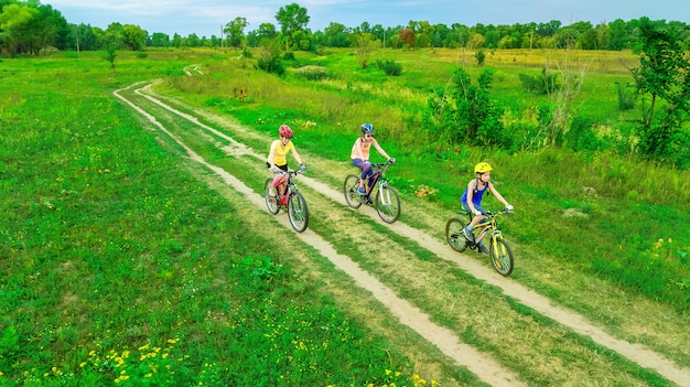 Familienradfahren auf Fahrrädern im Freien Luftaufnahme von oben, glückliche aktive Mutter mit Kindern haben Spaß, Familiensport und Fitness