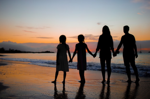 Familienschattenbild im Sonnenuntergang am Strand