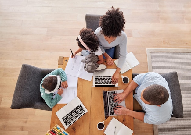 Familienschreibtisch und Laptop für die Arbeit im Wohnzimmer Eltern Kinder und Bildung Schwarze Frau Mann und Kinder arbeiten gemeinsam im Haus am Computer für Hausaufgaben online und lernen oben