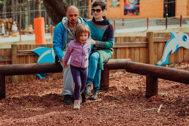 Familienspaß im Park. Glückliche Familie, die Zeit im Park verbringt und mit ihrer Tochter spielt.