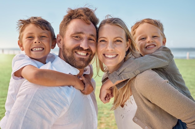 Foto familienstrand und huckepack-porträt mit kleinen kindern für urlaubsspaß im sommer mit den eltern lächeln glücklicher kinder mit mutter und vater, die sie am australischen ozean halten, um urlaub zu machen