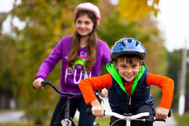 Familienurlaub. Bruder und Schwester im Park. Der Junge ist alleine auf dem Fahrrad.