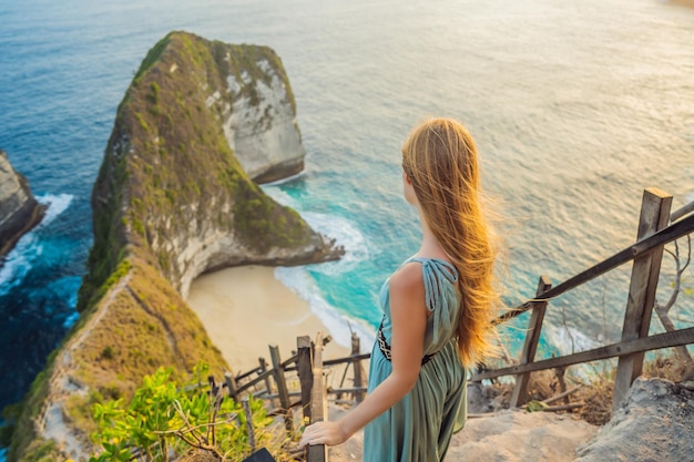 Familienurlaub Lifestyle Glückliche Frau steht am Aussichtspunkt Schauen Sie sich den schönen Strand unter einer hohen Klippe an Reiseziel in Bali Beliebter Ort für einen Besuch auf der Insel Nusa Penida