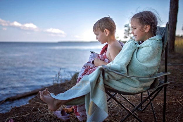 Familienurlaub vor Ort. Kinder, die das Meer nass betrachten, nachdem sie auf Campingplatz schwimmen, aktiver Lebensstil