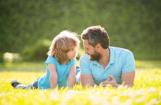 Familienwert Kindheit und Elternschaft entspannen sich mit kleinen Jungen auf Gras