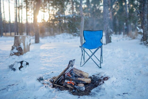 Familienwinter Picknick Lagerfeuer und Campingstuhl Winterspaziergang im verschneiten Wald am Wochenende horizontal