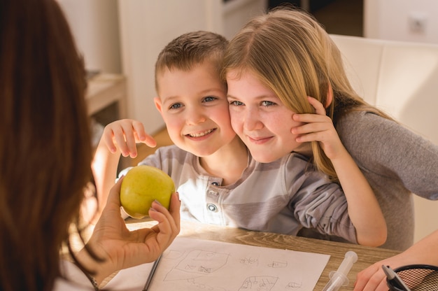 Familienzeit zu hause. mutter, die den kindern apfel gibt