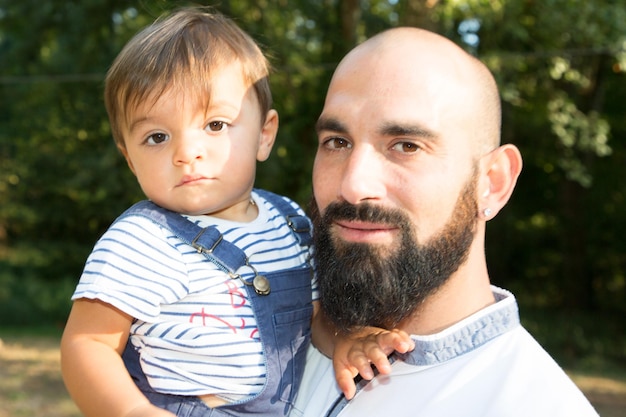 familiesommersohnbartglatzekindliebeglücklichmenschenniedlichporträtvaterlächelnmannjungkaukasiermännlichkindheitspaßzusammenglücklichelternteilparkerwachsenervaterfreude