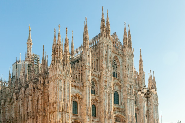 Famosa igreja Catedral de Milão, Duomo di Milano, com torres góticas e estátuas de mármore branco.