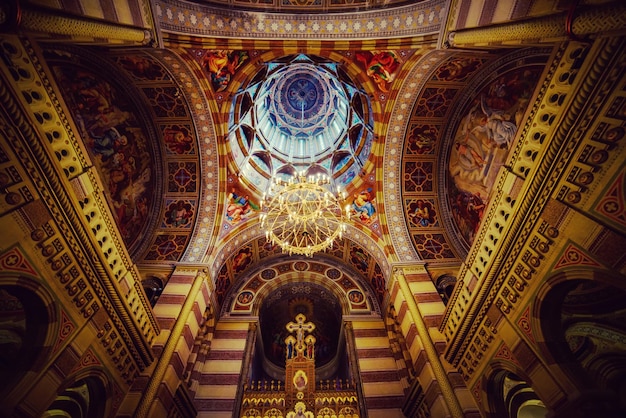 Famosa Igreja Ortodoxa dos Três Santos na cidade de Chernivtsi Ucrânia Interior com decoração dourada e grande candelabro