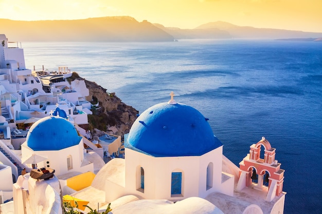 Famosa vista icónica de Santorini Cúpulas azules y casas blancas tradicionales durante la puesta de sol Pueblo de Oia Isla de Santorini Grecia