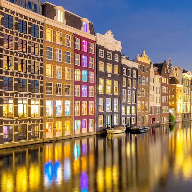 Famosas casas antiguas de Ámsterdam Las casas están en el agua y tienen un hermoso reflejo Distrito turístico Damrak Estas casas son famosas en todo el mundo Ámsterdam Holanda Europa