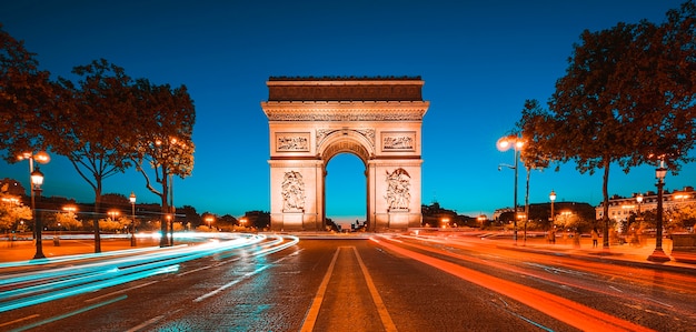 Famoso Arco do Triunfo à noite, Paris, França.