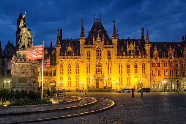 Famoso destino turístico grote markt square e edifício do tribunal provincial em bruges, bélgica, ...