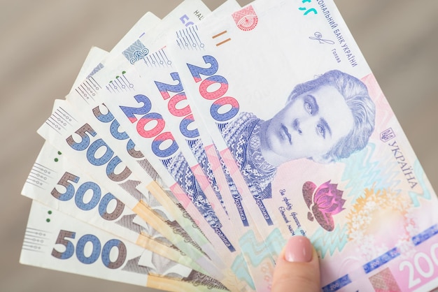 Fan von ukrainischen Banknoten in 200 und 500 Griwna-Nominalwerten in weiblicher Hand aus nächster Nähe