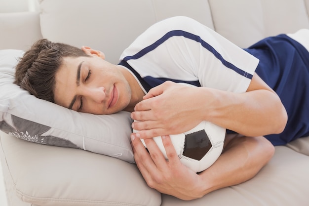 Fanático del fútbol durmiendo con pelota