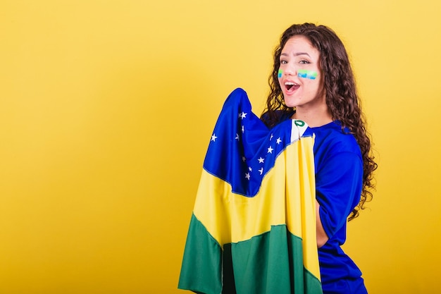 Fanático del fútbol femenino de la copa del mundo de brasil sosteniendo bandera y gritando gol