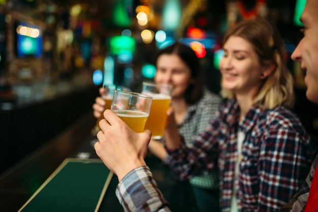 Los fanáticos del fútbol beben cerveza ligera en el mostrador del bar de deportes.