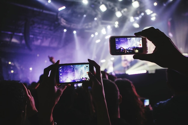 Foto los fanáticos con teléfonos inteligentes en un concierto musical