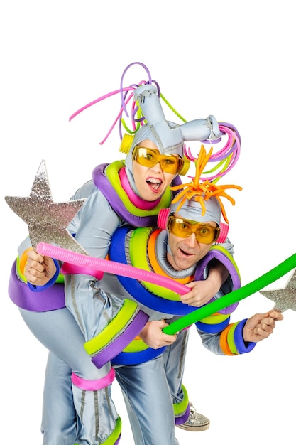 Fancy Dress Party Zwei fröhliche Clowns mit futuristischer gelber Brille und kreativen silbernen Metallic-Kostümen