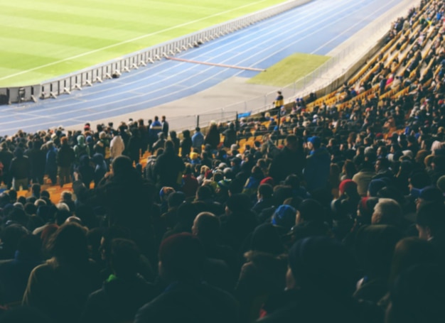 Foto fans, die fußballspiele im stadion sehen, verschwommenen hintergrund