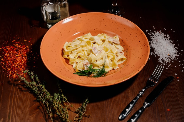 Fantasia de macarrão fetuccine orgânico com molho cremoso de cogumelos Alfredo.