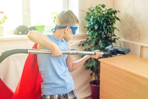 Fantasia de super-herói menino brincando é limpando a casa