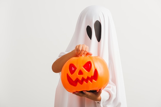 Fantasia infantil de halloween como fantasma com abóbora