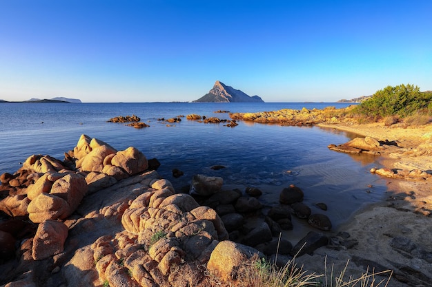 Fantástica agua azul con rocas cerca de la playa Porto Taverna al atardecer
